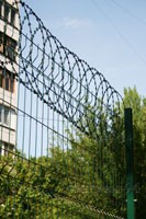 Плоское колючее ленточное заграждение с ПВХ покрытием на заборе